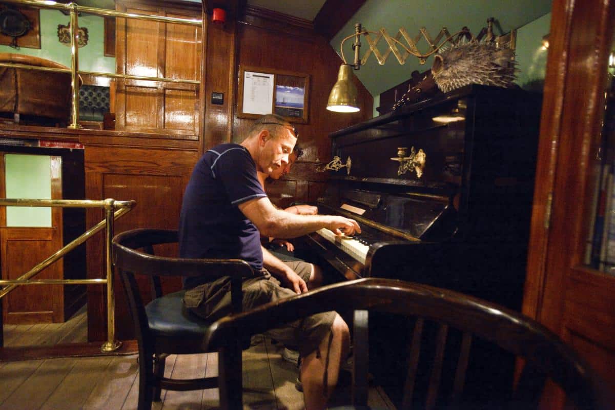 Guests playing the piano in Oosterschelde's saloon