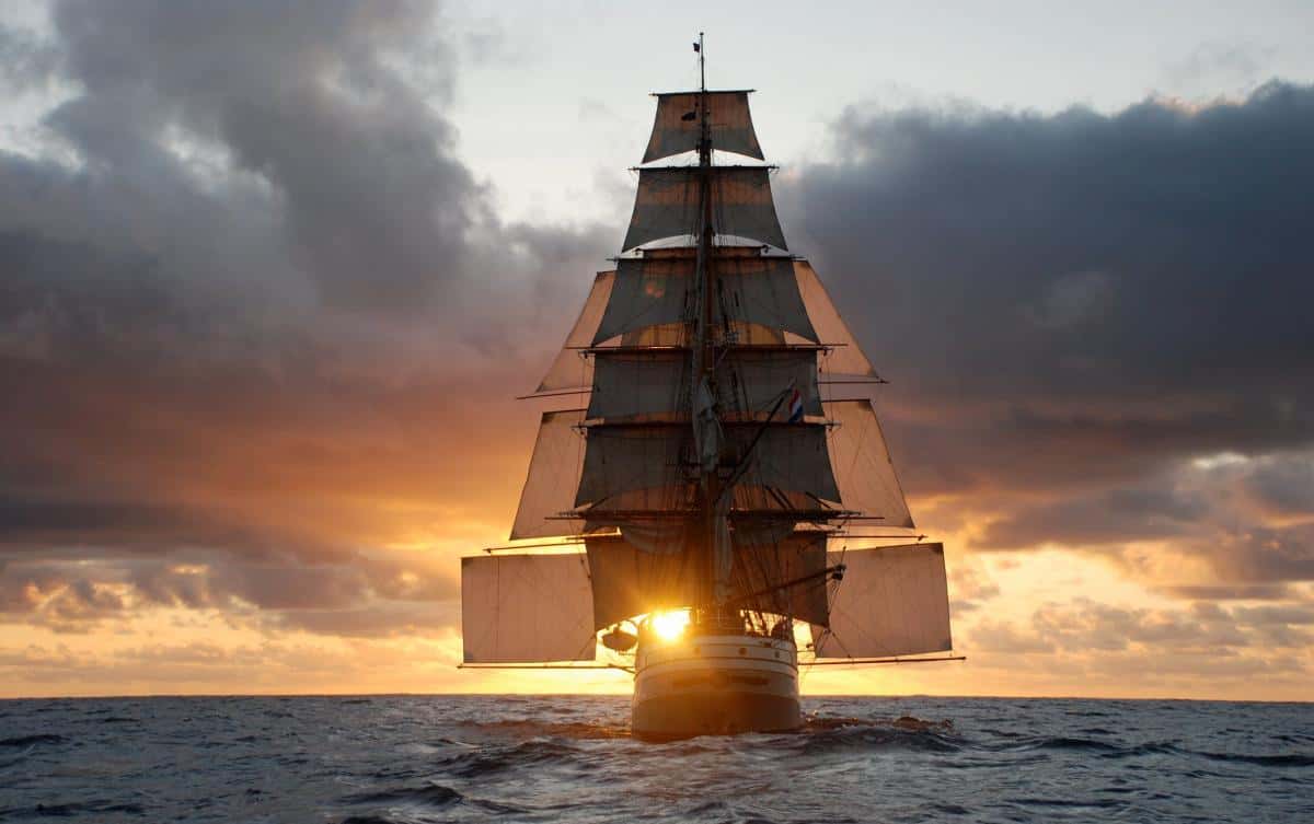 square rigger in the sunset with stunsails