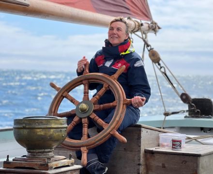 People help make an unforgettable sailing holiday. Provident's Morag helming with a smile and concentration.
