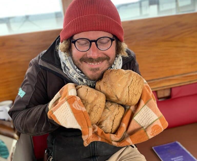 Grayhound crew with a big smile, holding freshly baked bread