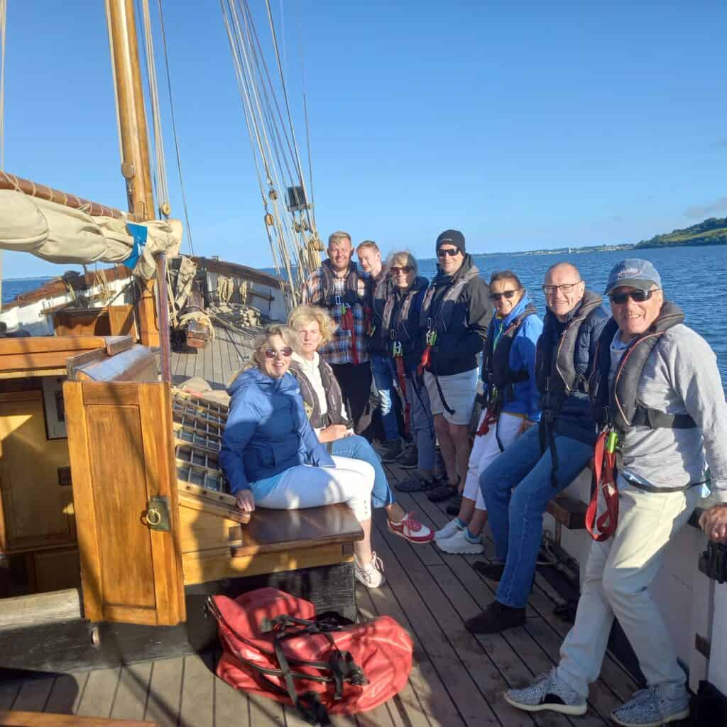 Happy guests and crew on the deck of Leader