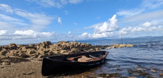 Grayhound lugger in the Hebrides. Rowing boat ashore.