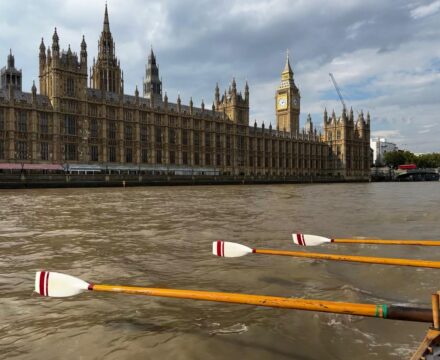 Houses of Parliament Westminster London from a Cornish Pilot Gig Boat. Stroke side oars all in time together.